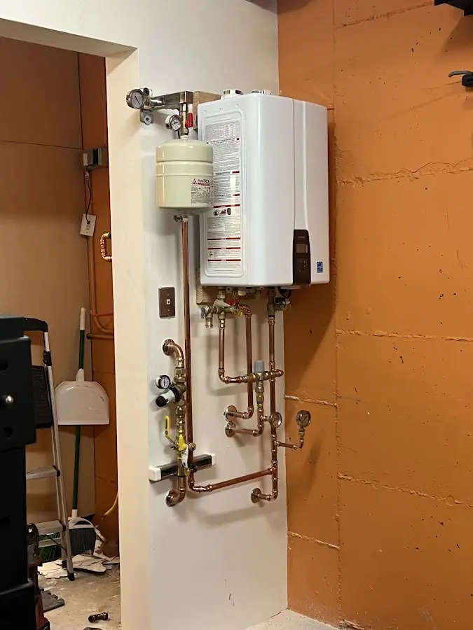 Plumbing technician inspecting water heater connections in Crossett